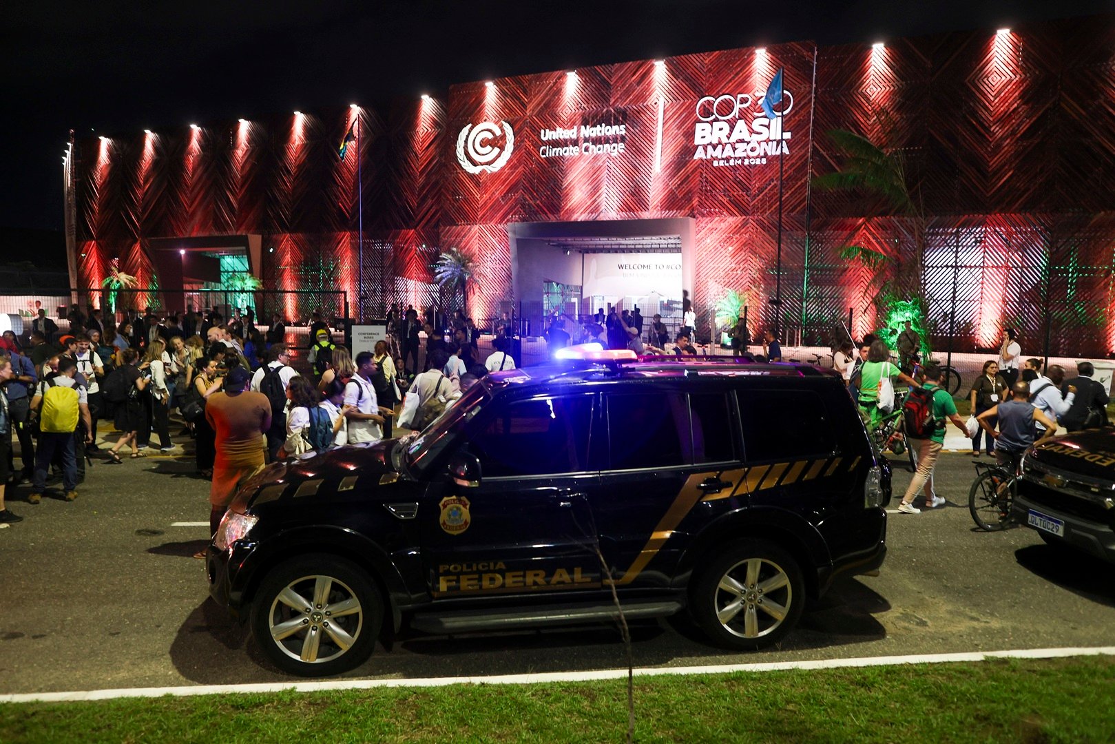 Ambul&acirc;ncias e carros da PF (Pol&iacute;cia Federal) em frente &agrave; entrada da Zona Azul da COP30, na noite de 3&ordf; feira (11.nov.2025), depois de tentativa de invas&atilde;o do local por manifestantes