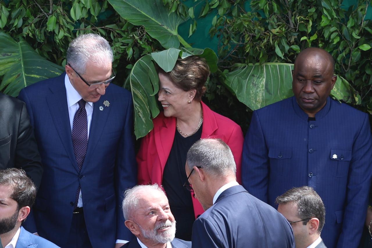 Dilma ri com a folha da planta em cima de seu rosto antes da "foto de fam&iacute;lia" da C&uacute;pula de L&iacute;deres da COP30